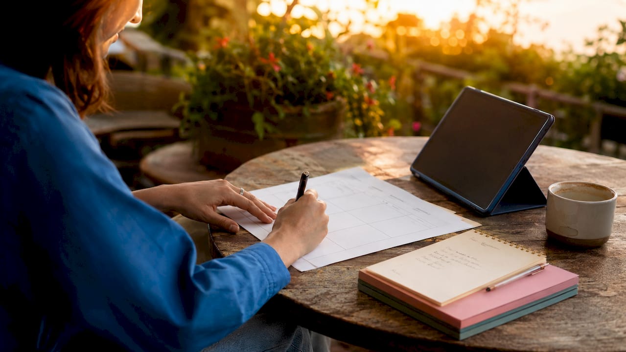 Hands completing a digital marketing plan template