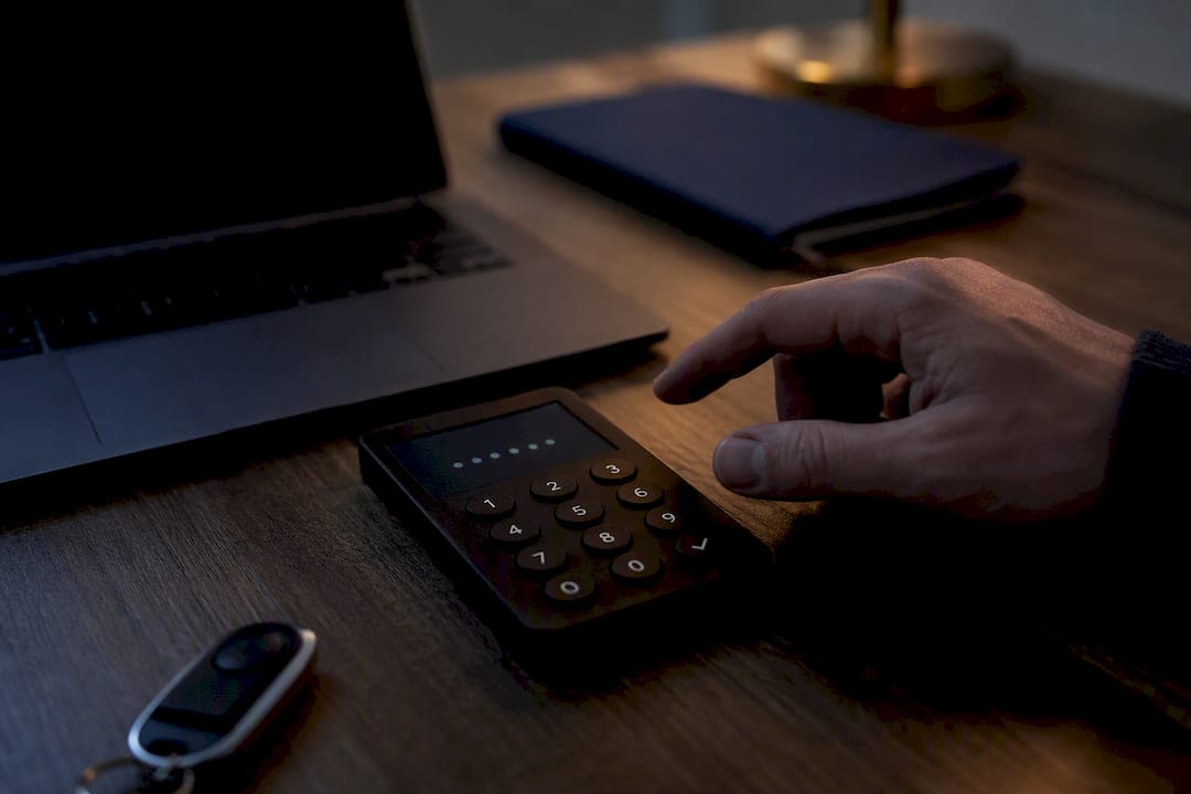Hand typing password on dark screen