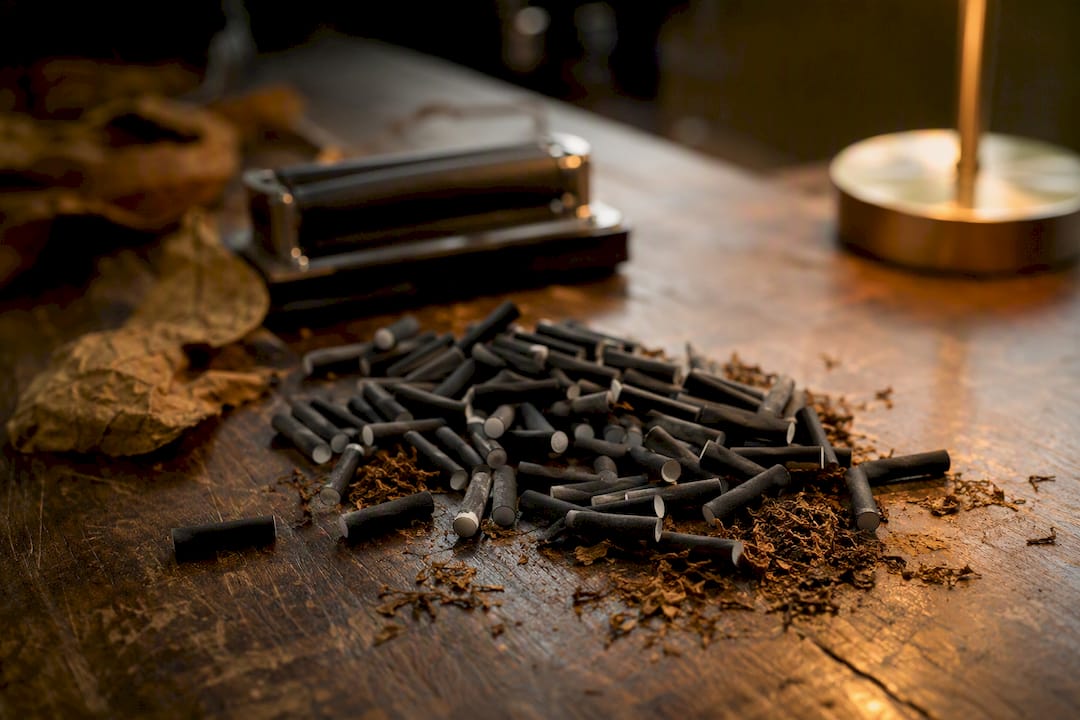 Close-up of charcoal filter tips near rolling machine