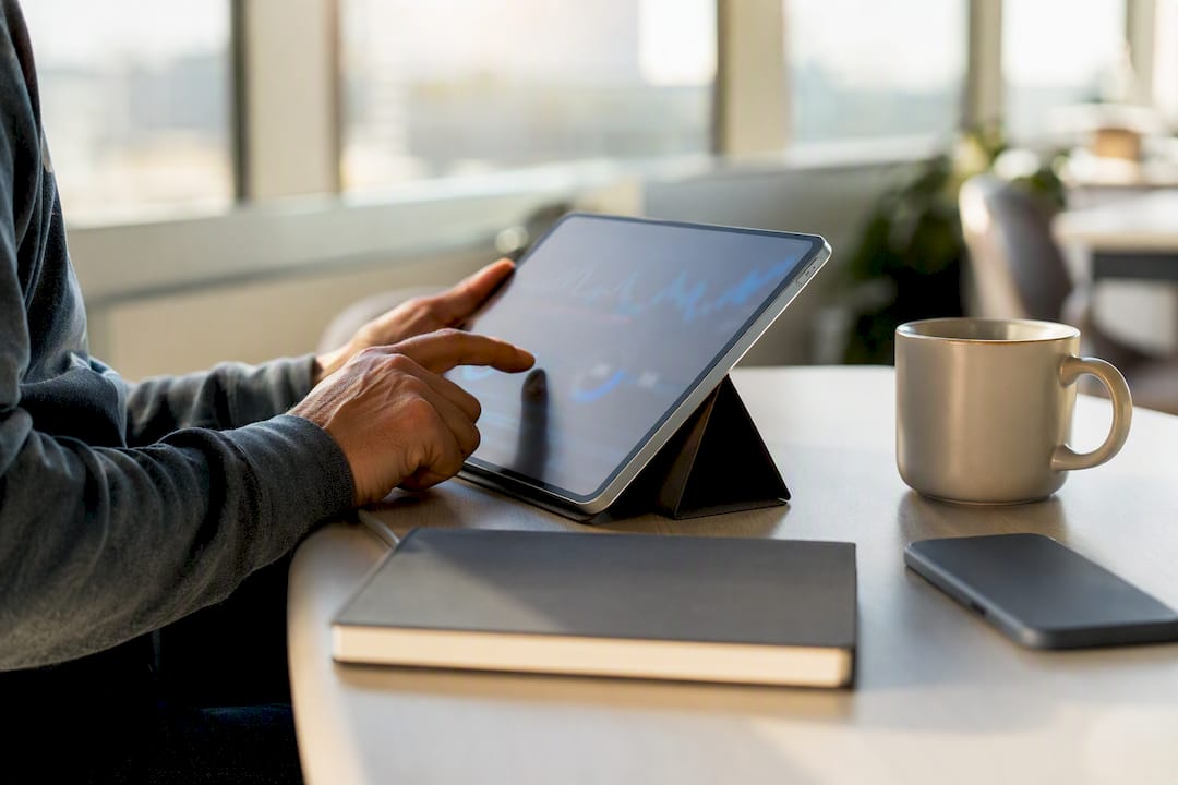 Hand interacting with tablet showing analytics