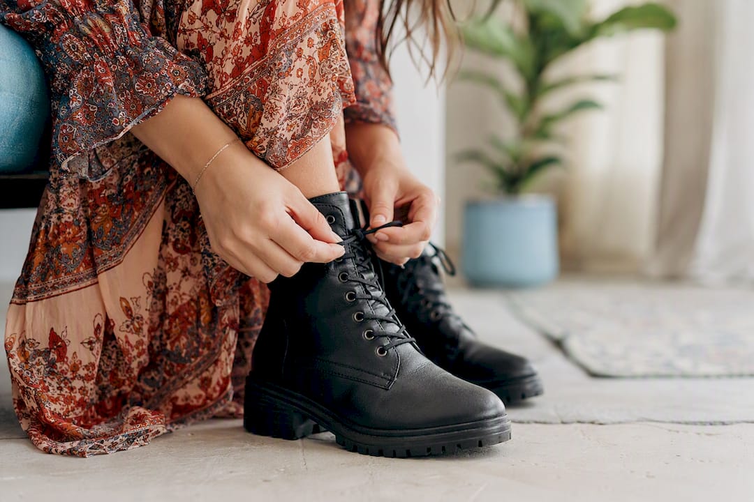 Hands lacing vegan combat boots close-up