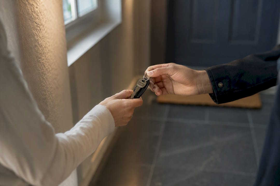Deux personnes se passent une clé électronique dans le couloir.