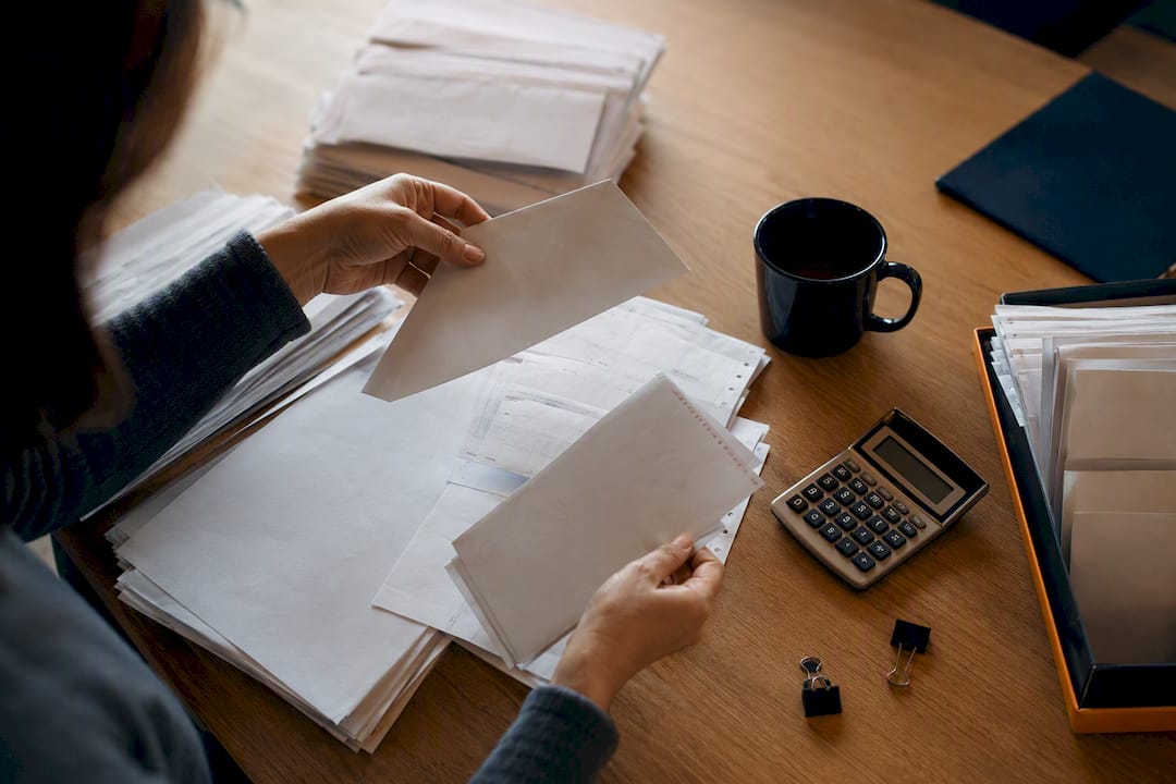 Mains triant des documents de paiement sur un bureau