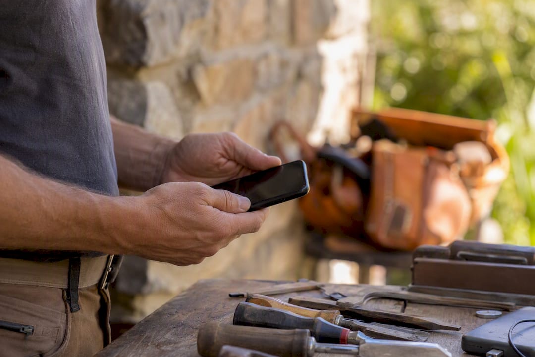 Tradesperson handling smartphone for invoicing