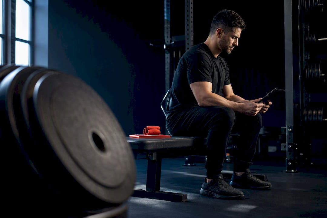 Strength coach reviewing programme in gym