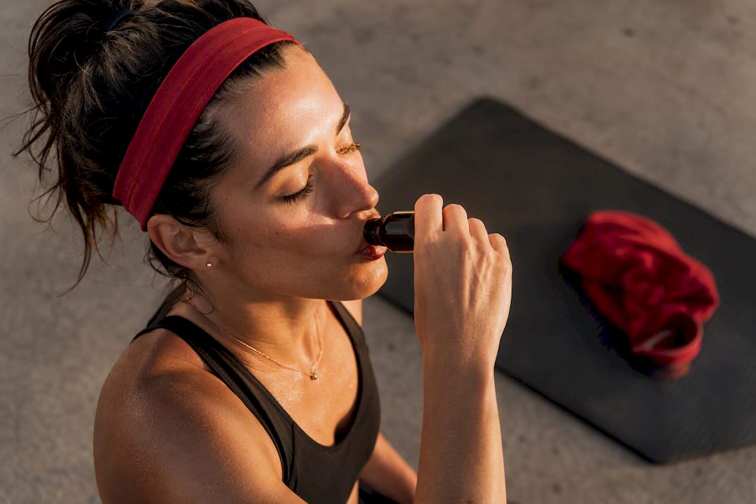 Person taking botanical energy shot before workout
