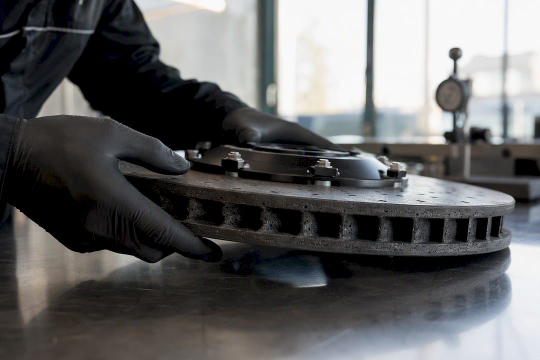 Hands inspecting carbon ceramic brake rotor