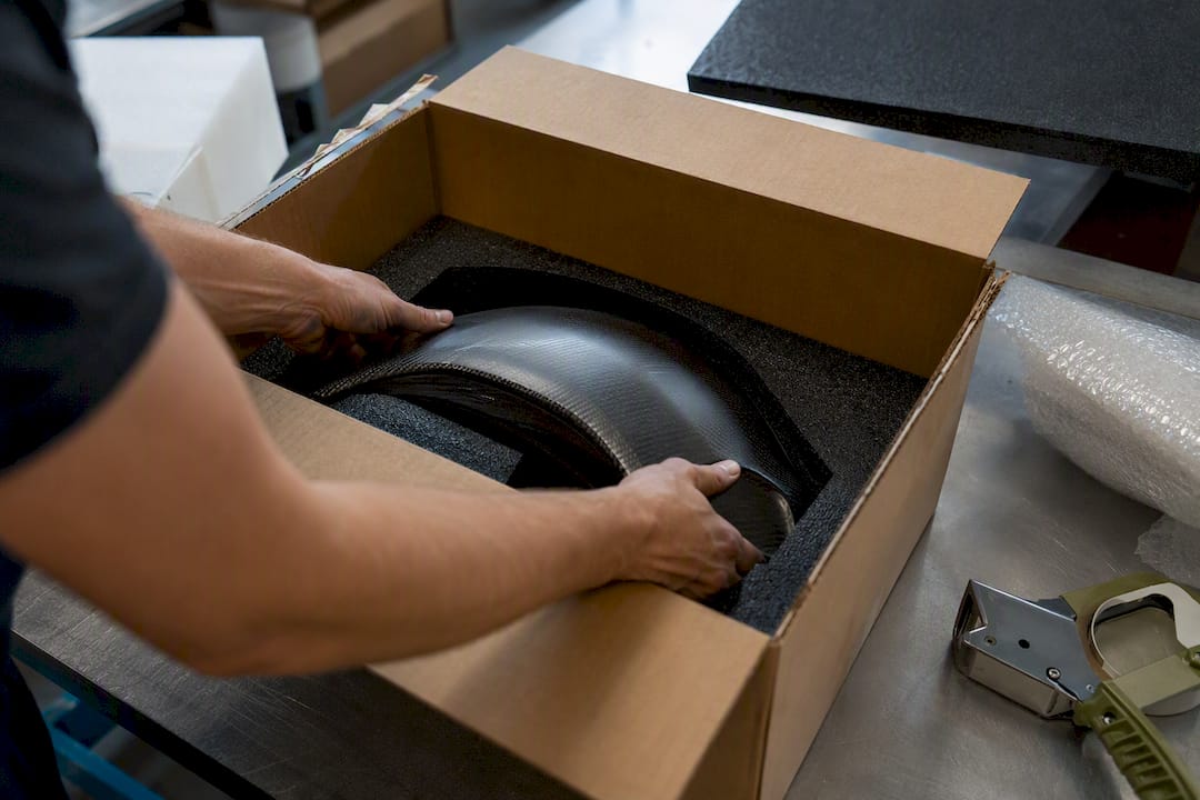 Hands packing supercar part for shipping