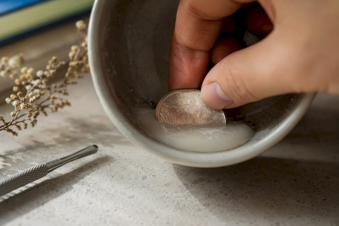 Silver coin revealed inside cooled candle wax