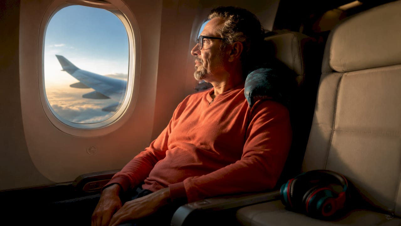Passenger sitting at wing window seat looking outside