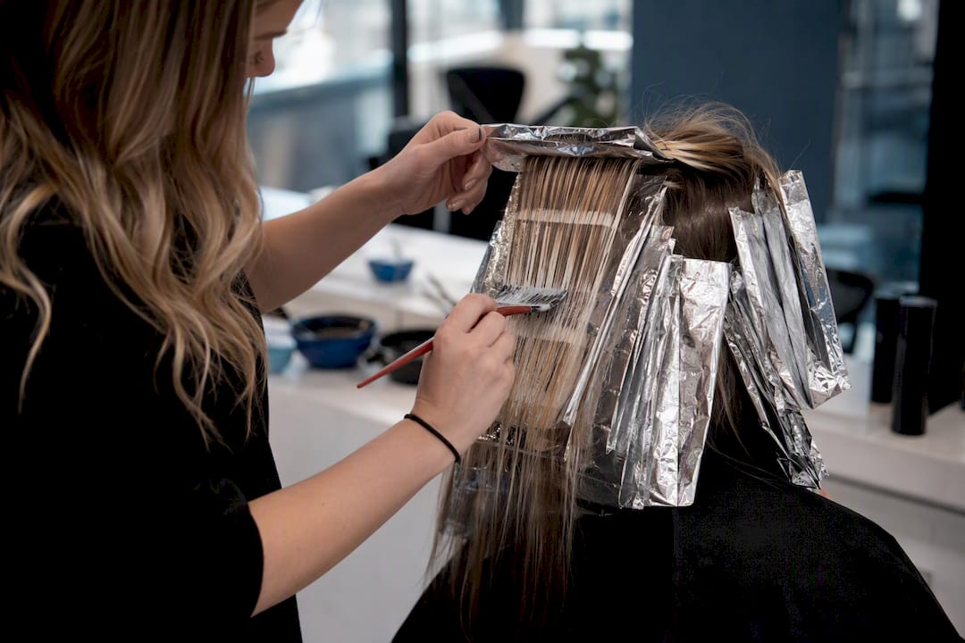 Stylist applying hair color correction in salon