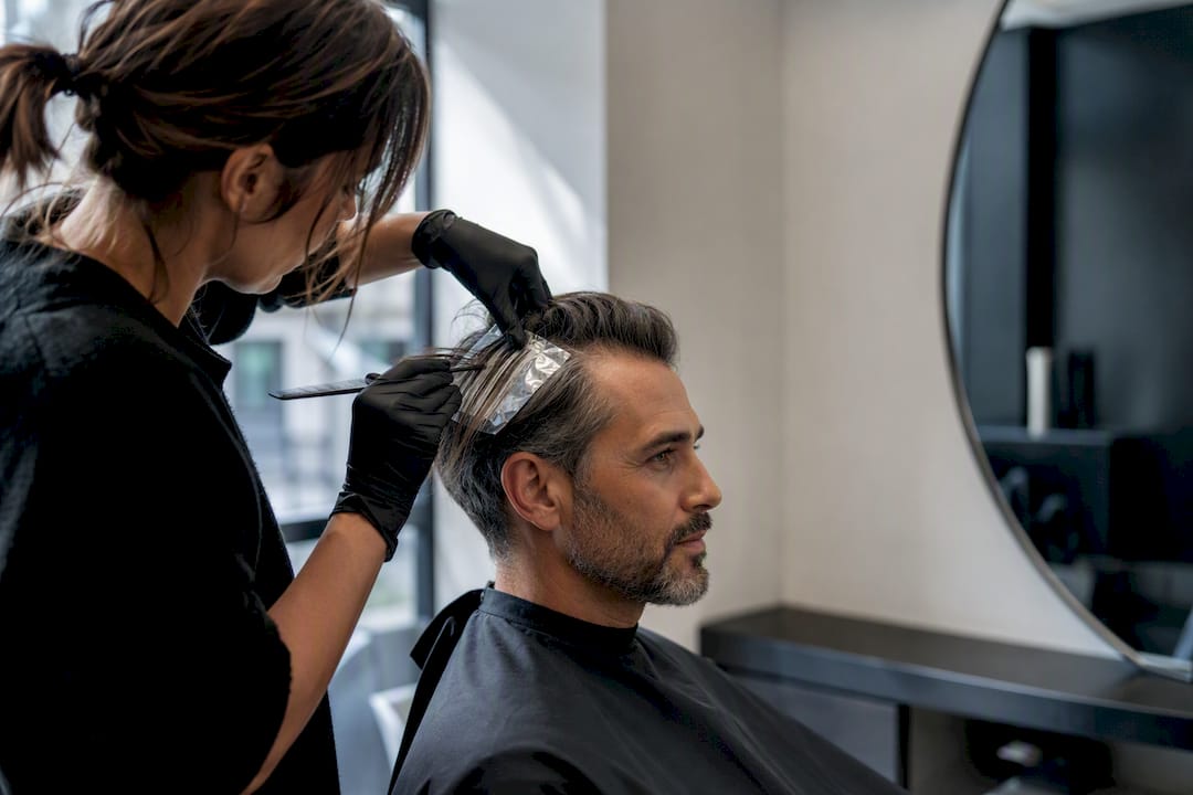 Stylist applying subtle men's grey blending