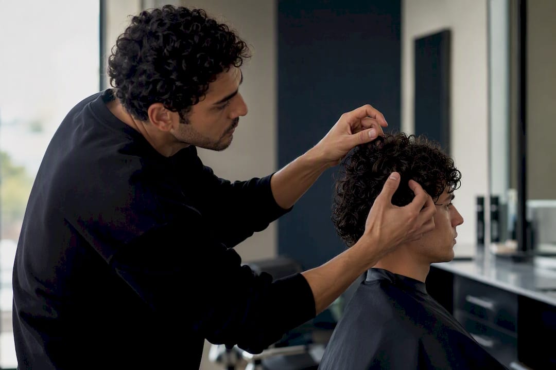 Stylist checking curly hairline and cowlicks