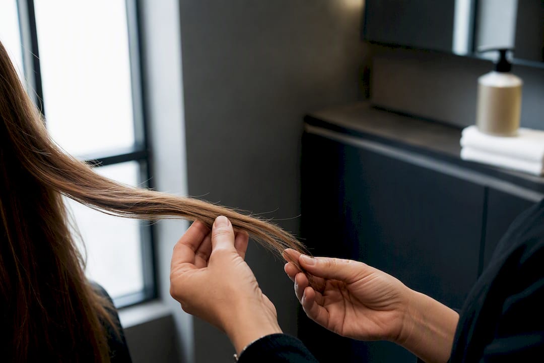Stylist examining hair strands for damage