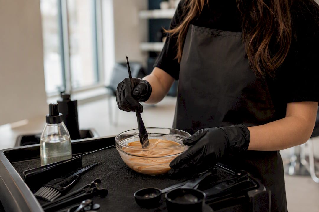 Stylist mixing hair color at salon workstation
