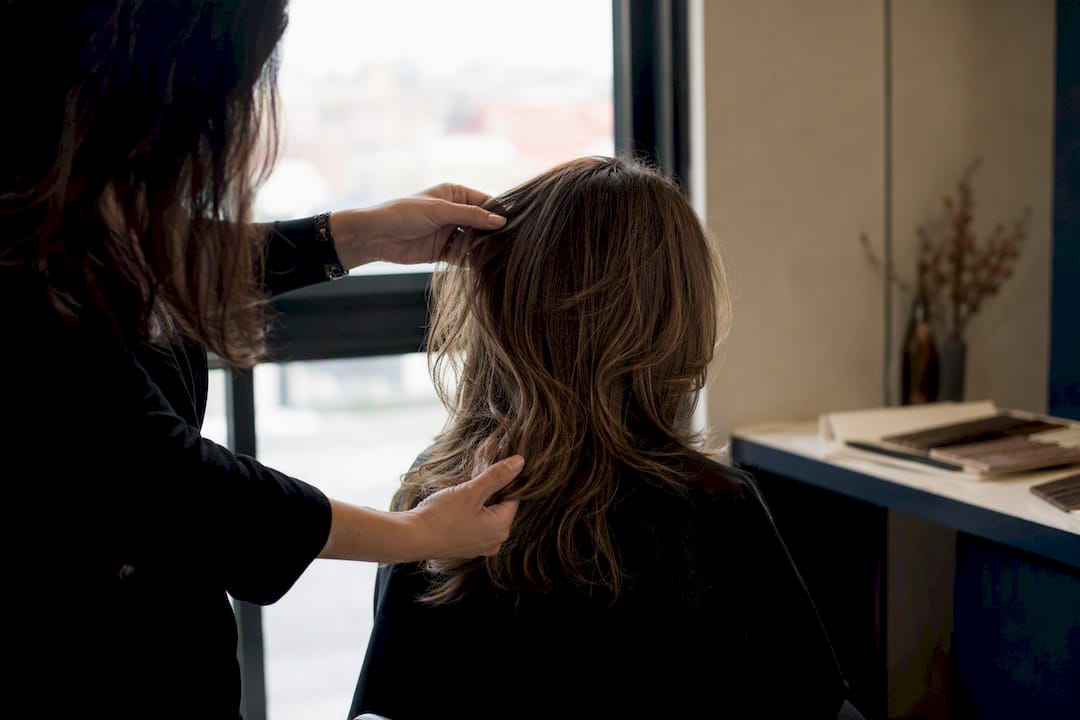 Stylist examining hair layers in natural light