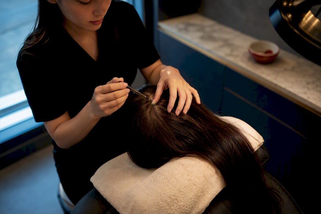 Professional applying a salon scalp treatment