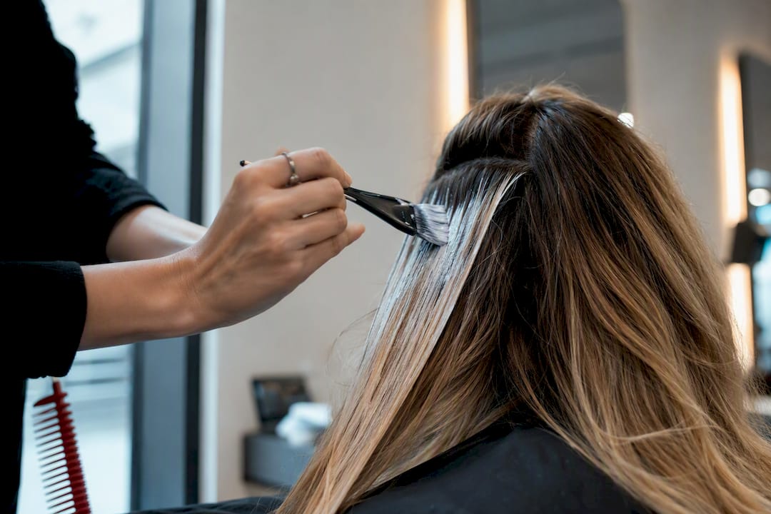 Colourist hand-painting balayage through hair