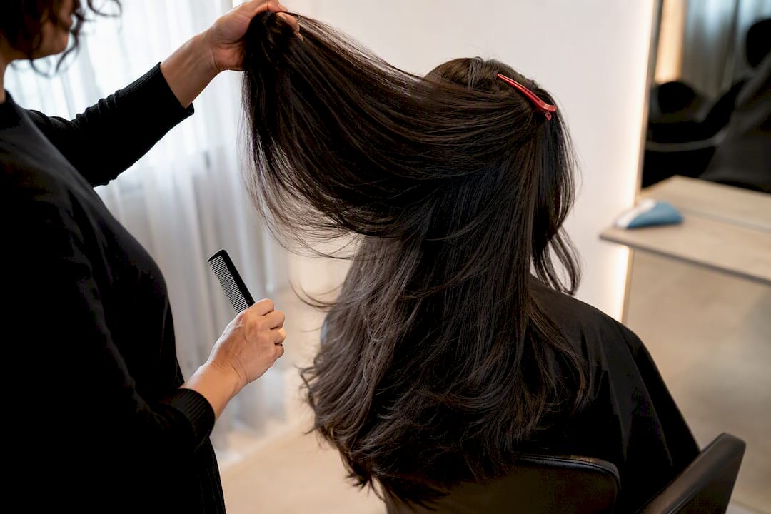 Stylist revealing internal layers in thick hair