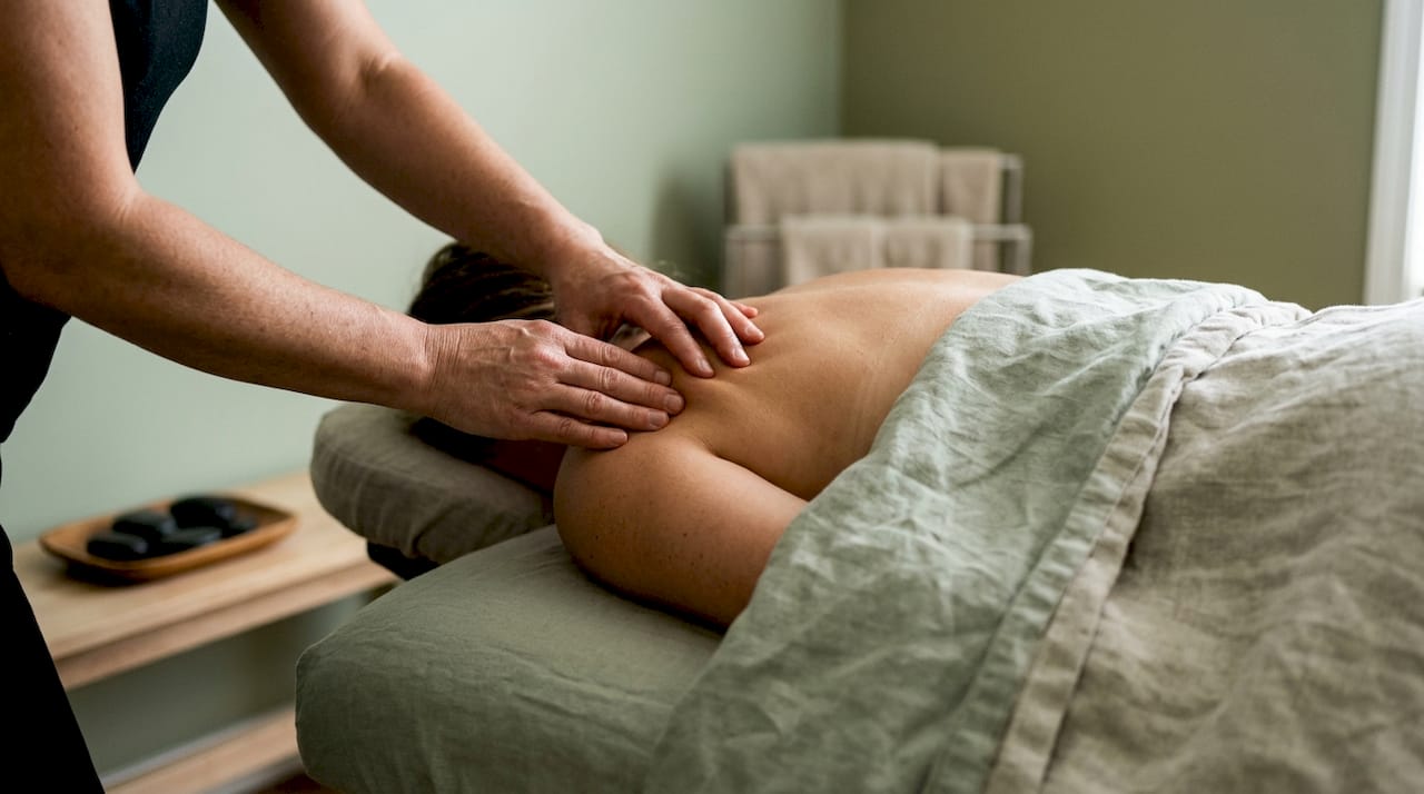 Therapist hands kneading shoulder muscle