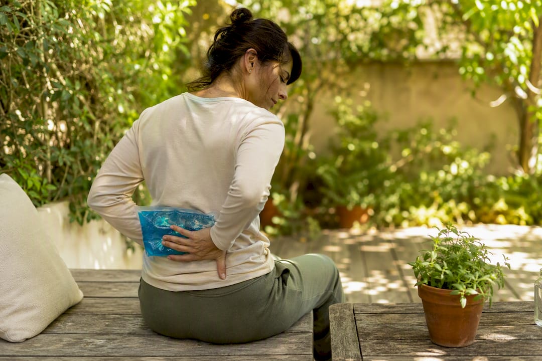 Person applying ice pack on lower back
