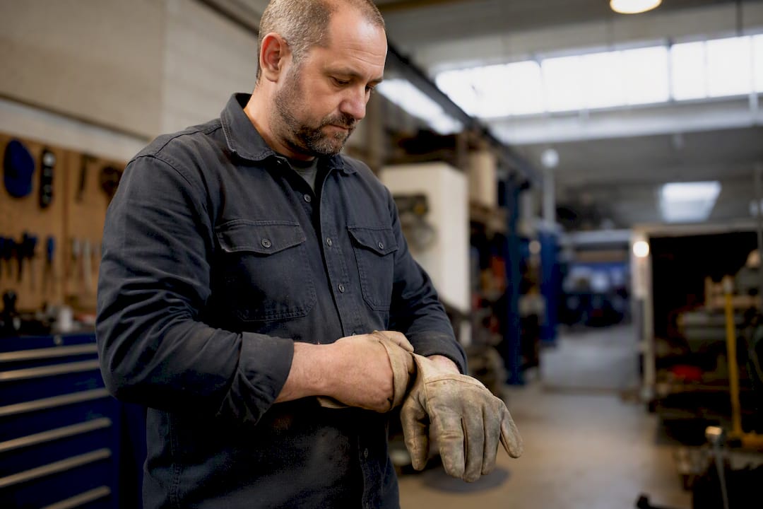Hands adjusting work gloves on light duty return