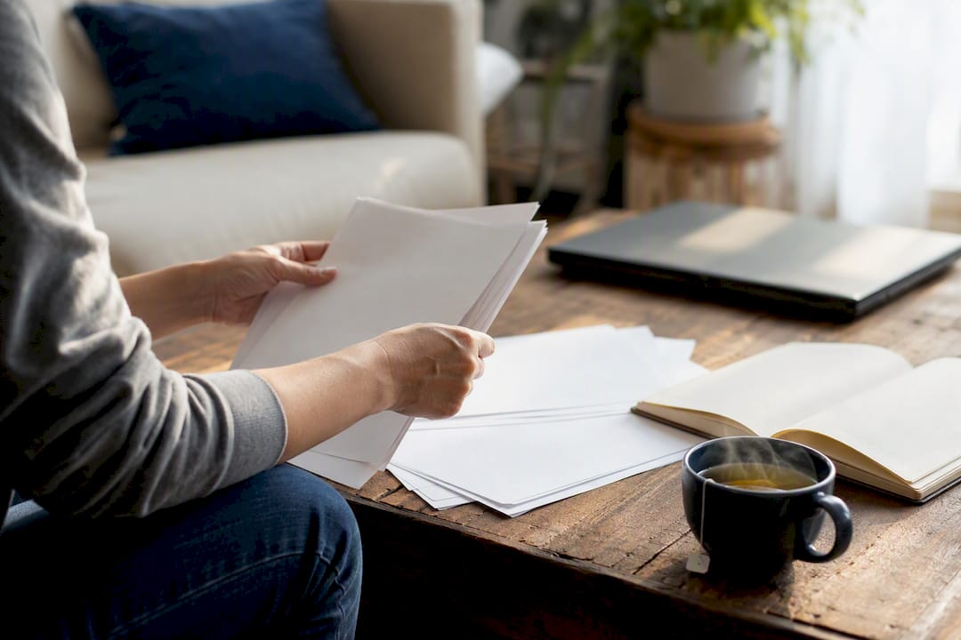Hands flipping through settlement paperwork