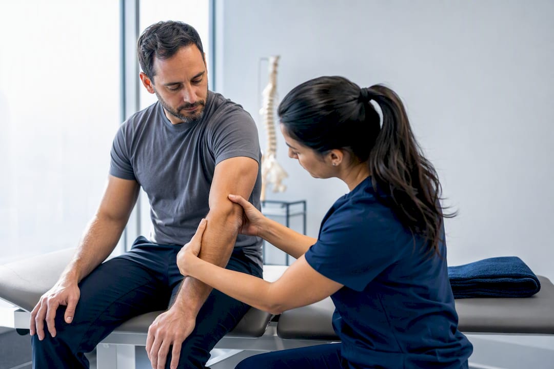 Clinician examining injured worker in treatment room