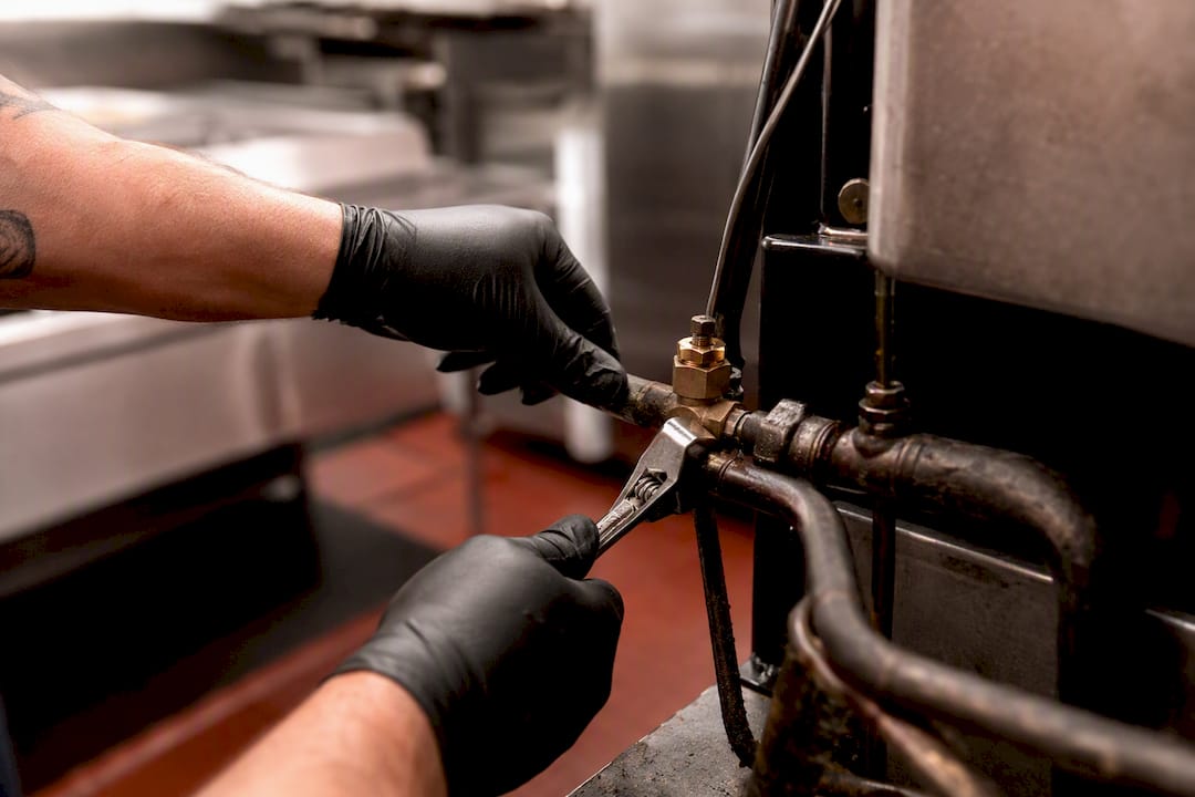 Hands inspecting refrigeration pipe fitting