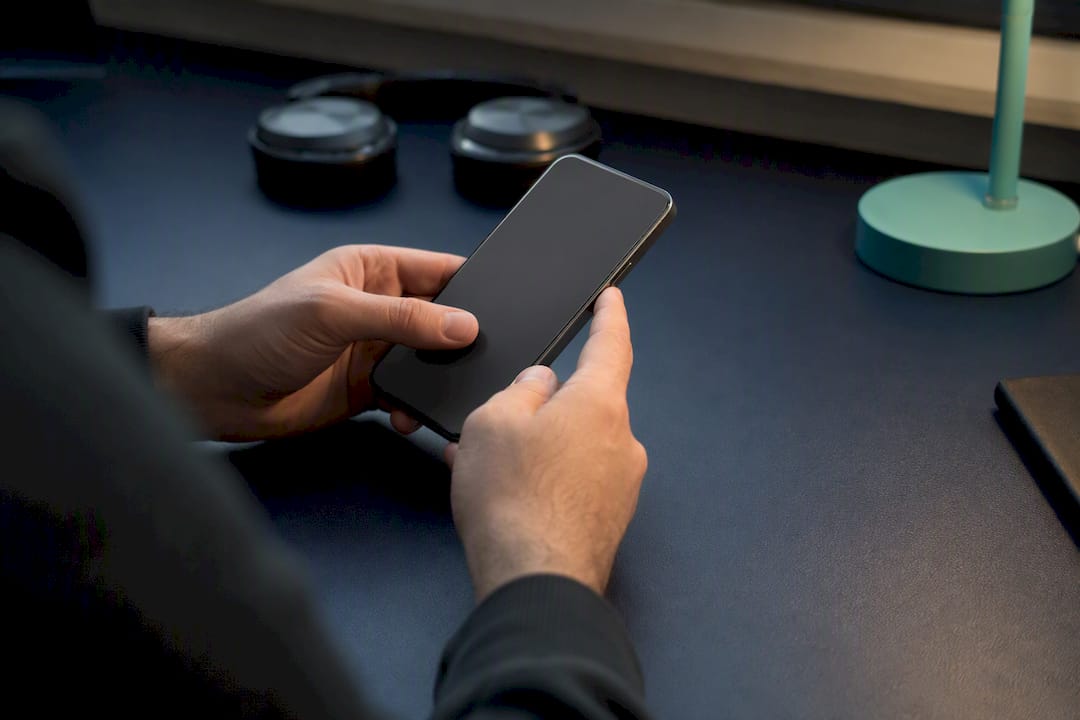 Hands pressing button beside smartphone