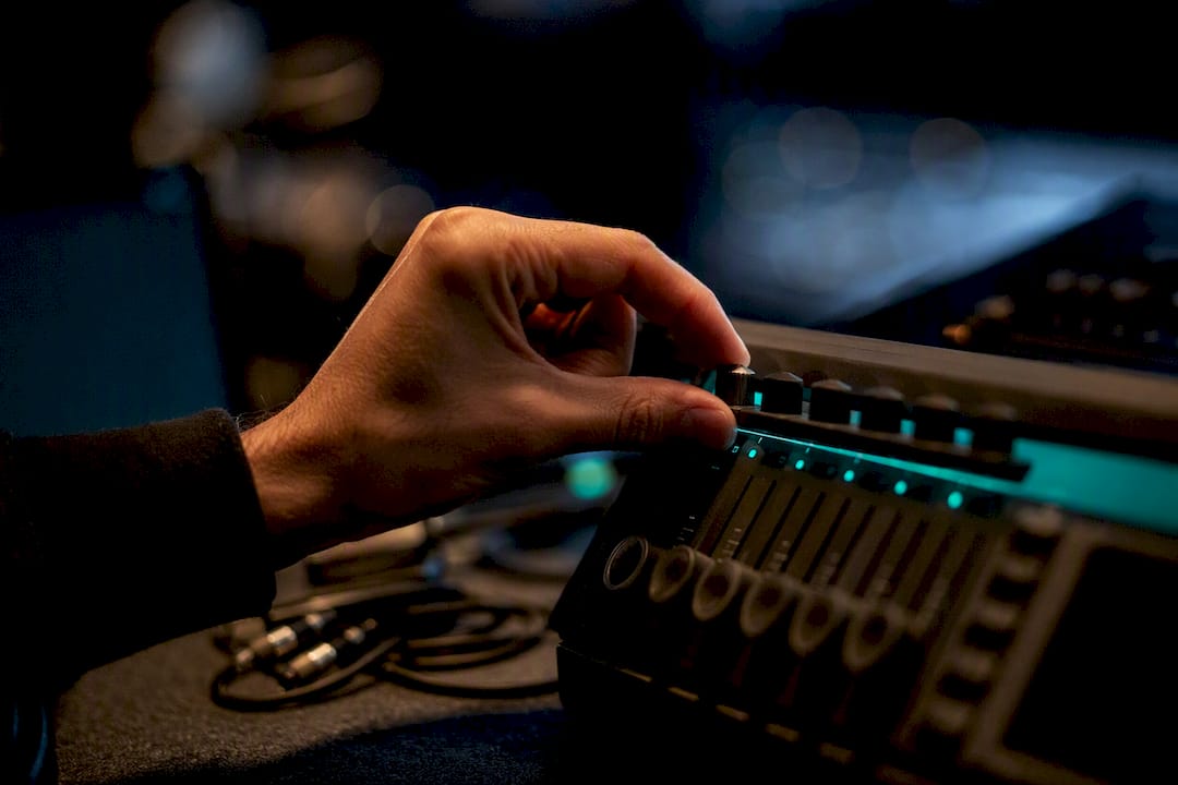 Hand adjusting volume on audio hardware
