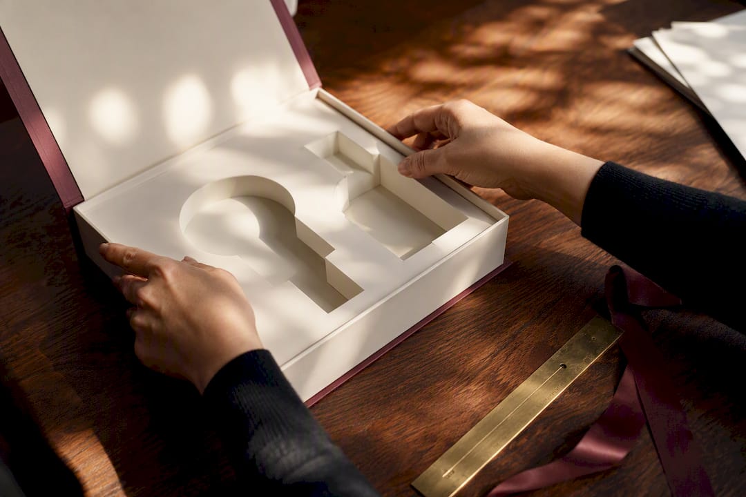 Hands inserting a fitted insert into a luxury cosmetic box