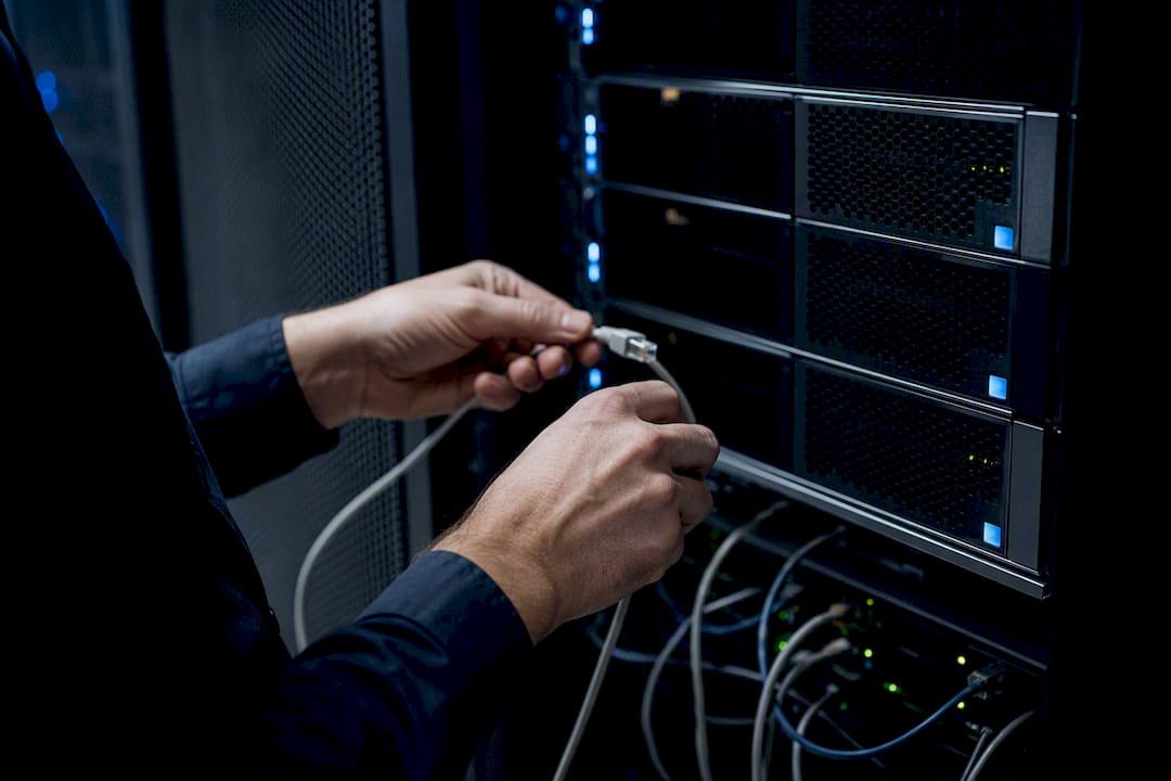 Hands unplugging server network cable