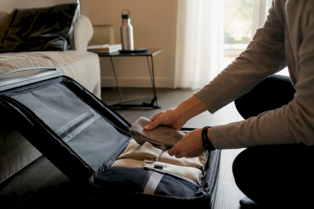 Händer som packar kompressionsstrumpor i resväskan