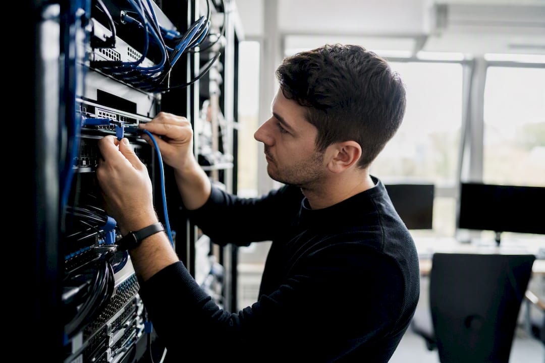 Hands connecting server cables in data center