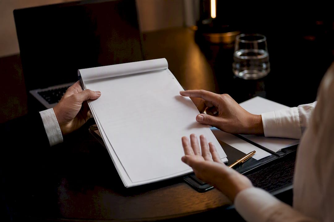 Hands coordinating supplier contract compliance checklist