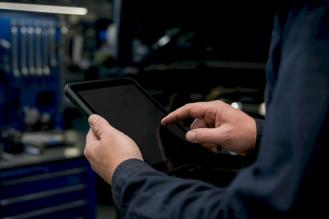 Techniker gibt Fahrzeugdaten auf dem Gerät ein