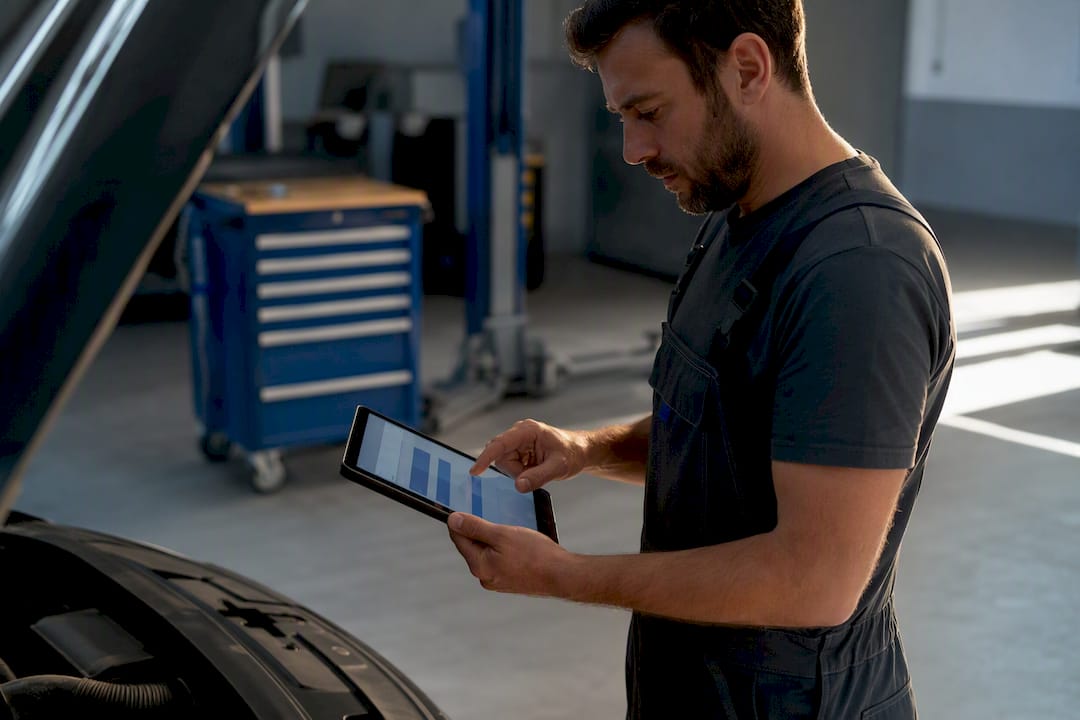 Mechaniker hält den Arbeitsauftrag auf dem Tablet fest