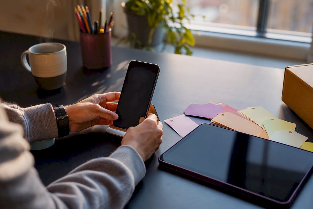 Hands preparing social media content items on a desk