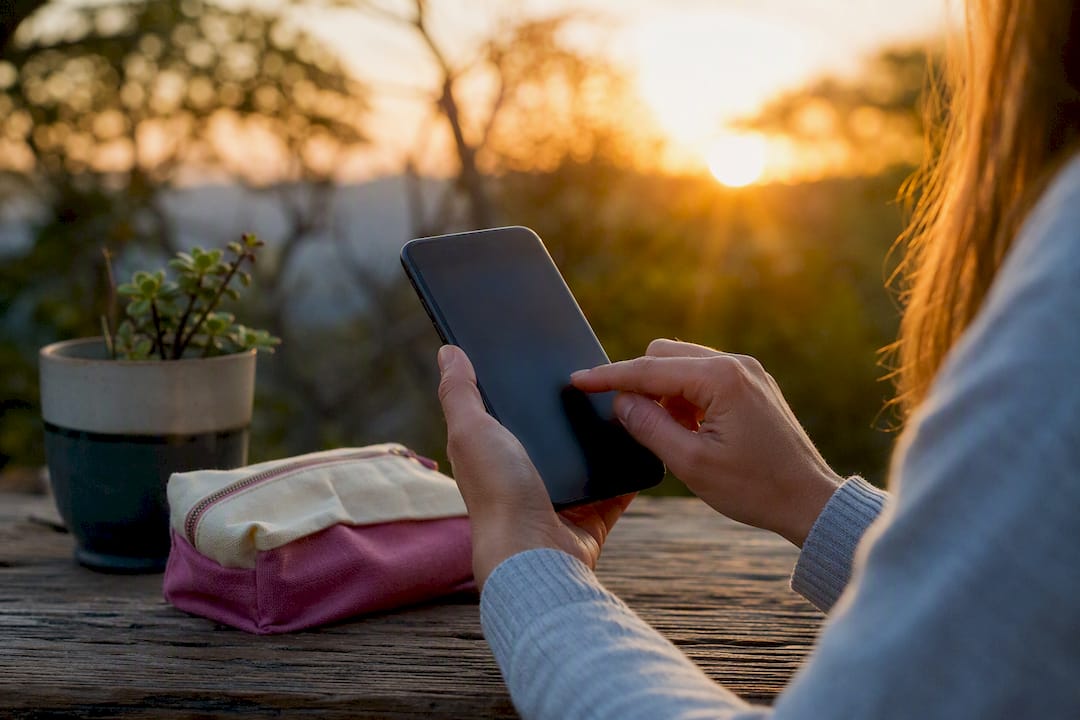 Person's hands holding smartphone for social service
