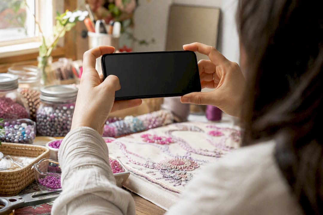 Hands filming craft process on smartphone