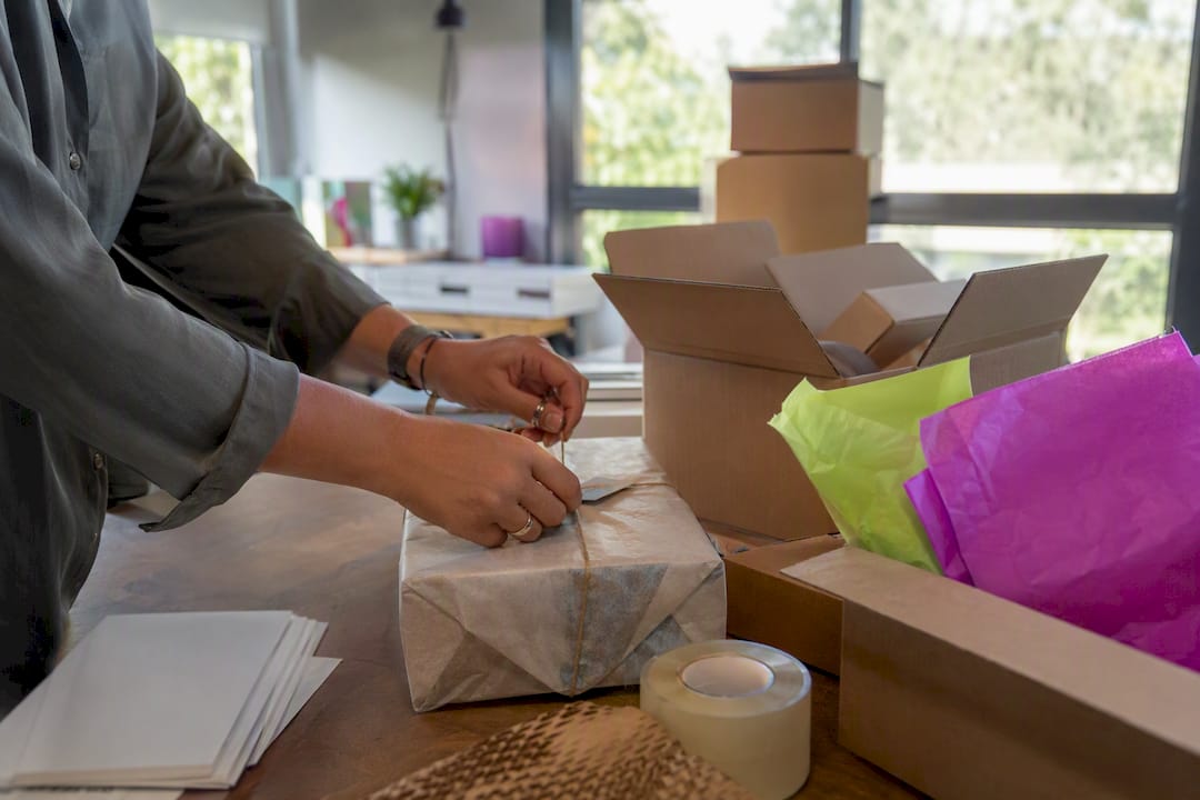 Hands taping ecommerce package for shipment