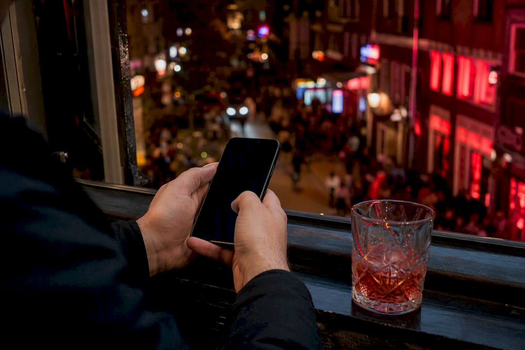 Handen houden een mobiele telefoon met een zwart scherm vast