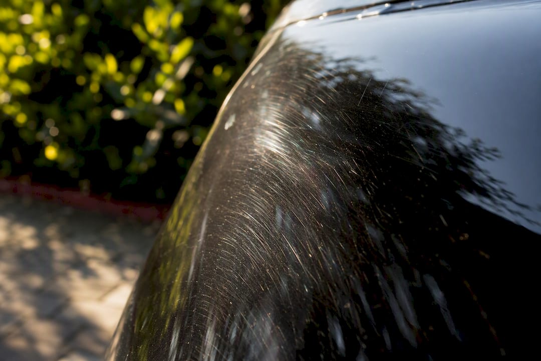 Swirl marks on black car paint surface