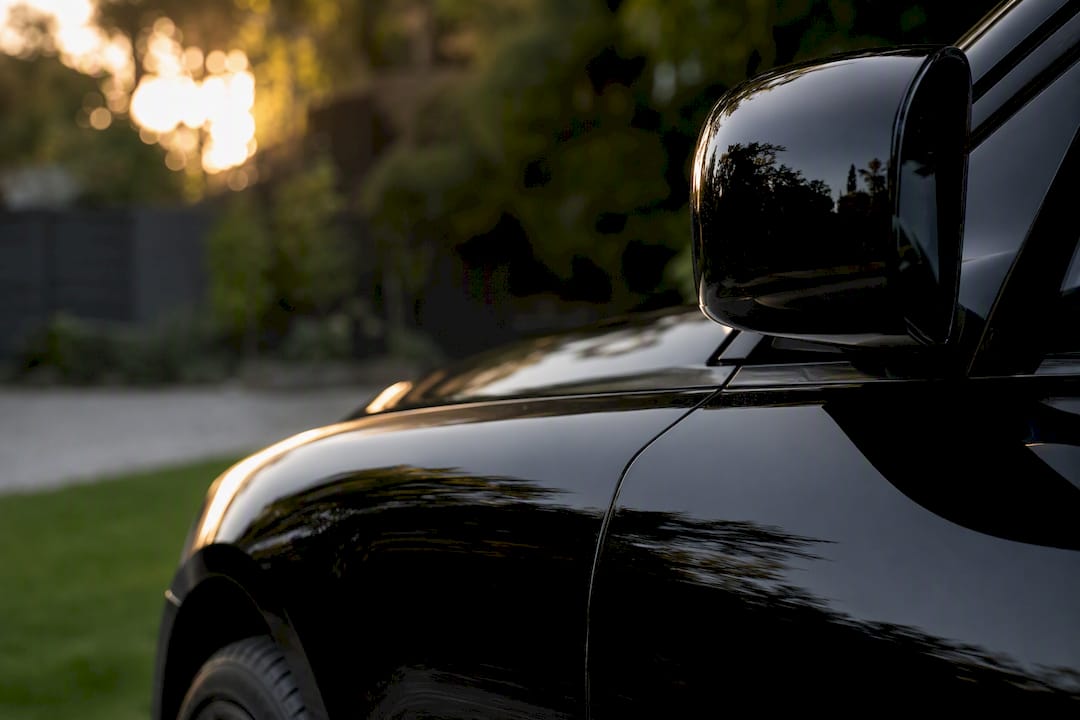 Close-up paint protection film on luxury car fender and mirror
