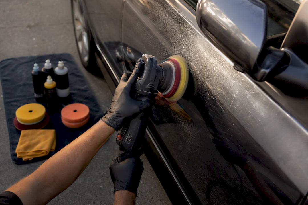 Detailer polishing car to remove etched water spots