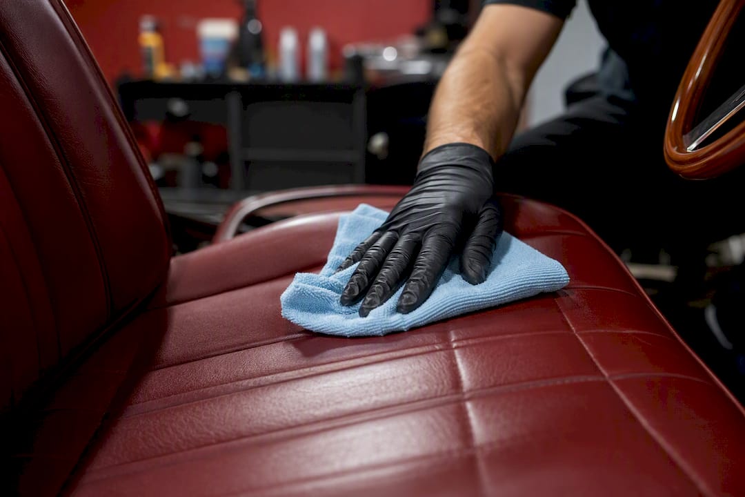 Gloved hand sanitizing leather car seat