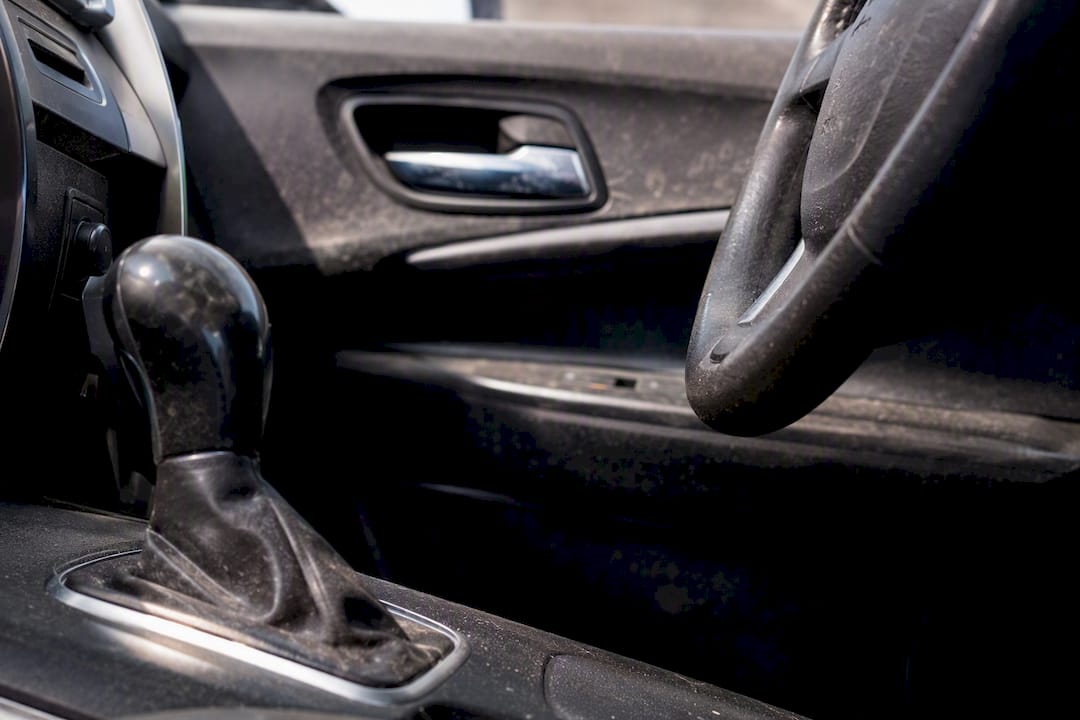 Close-up of dusty car steering wheel and door handle