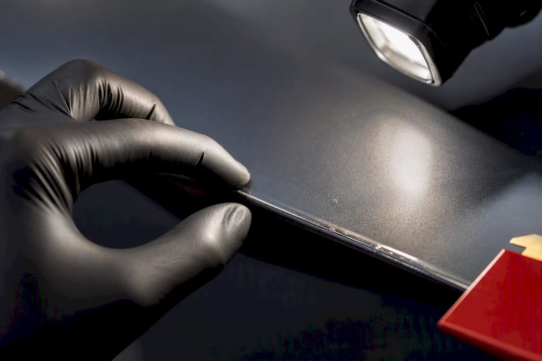 Installer inspecting PPF edge under light