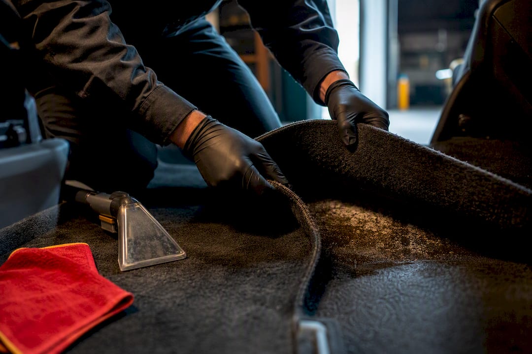 Technician inspecting gasoline-contaminated vehicle carpet